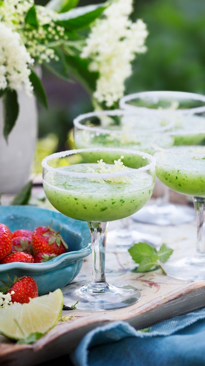 Glass of cucumber cocktail decorated with flowers