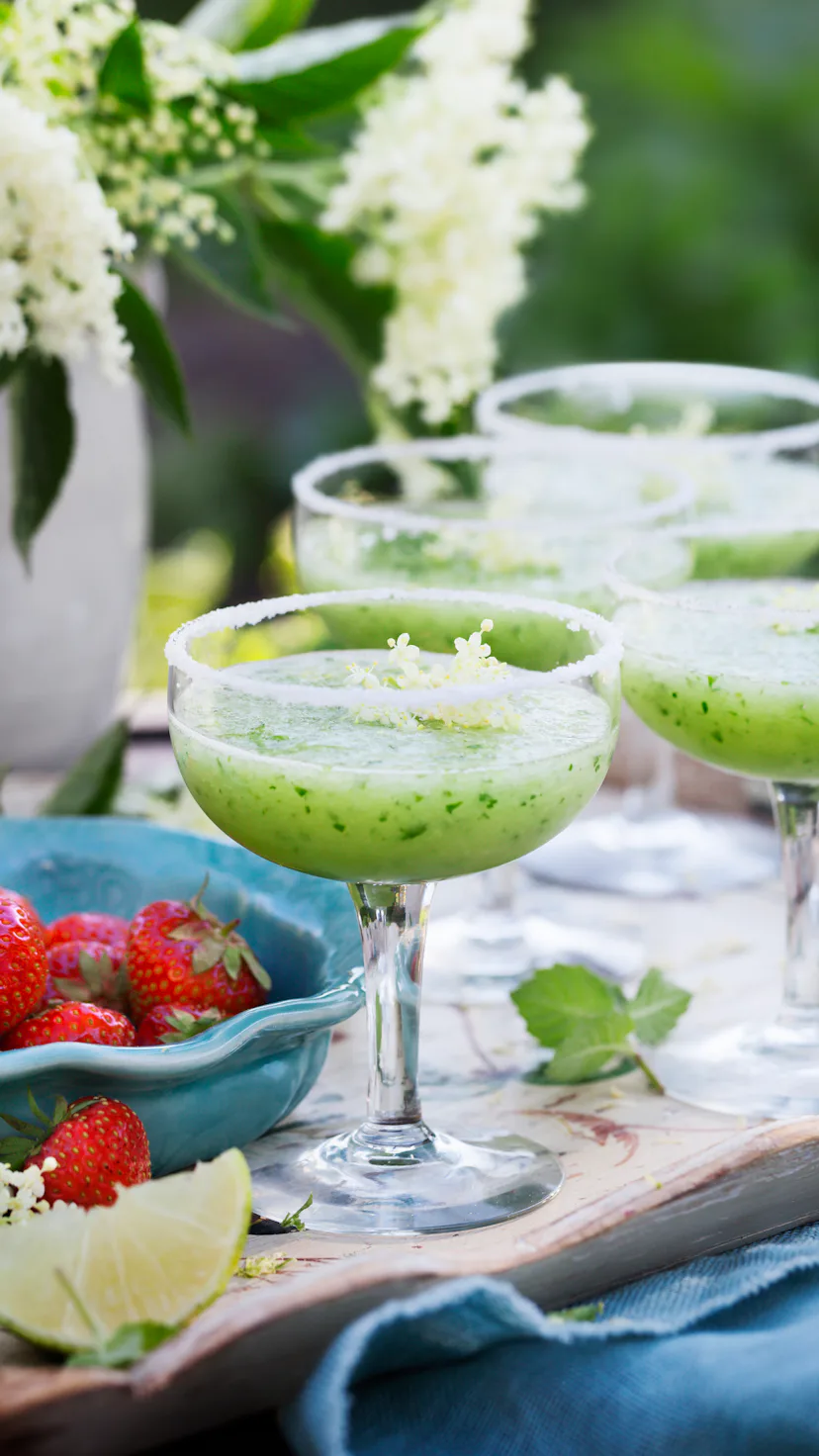 Glass of cucumber cocktail decorated with flowers