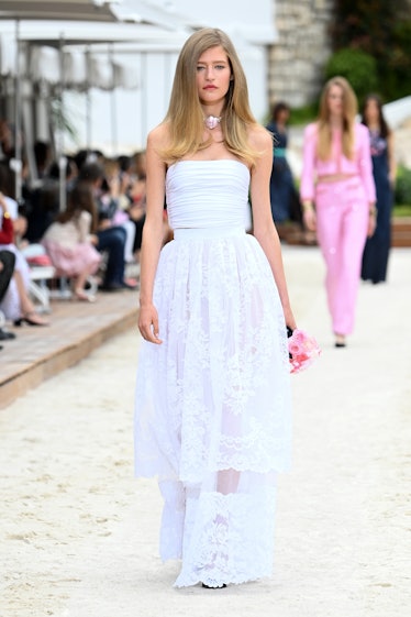 A model walking the runway for the Louis Vuitton's 2023 Cruise Show in a white gown