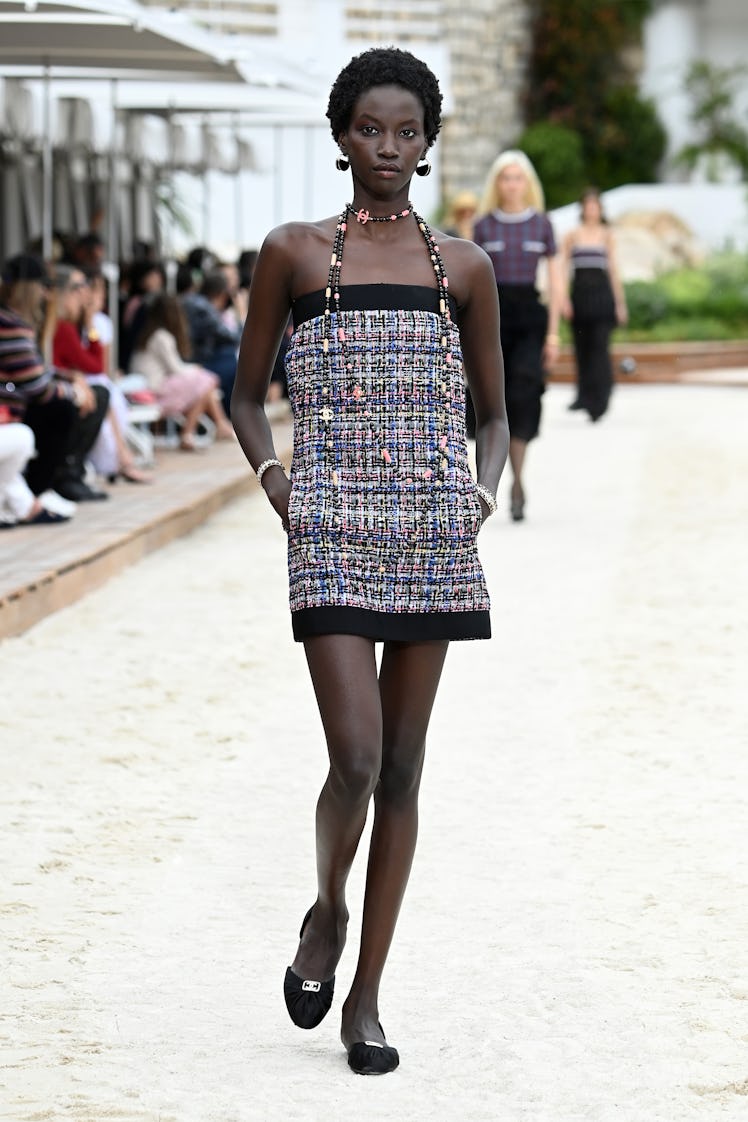 A model walking the runway for the Louis Vuitton's 2023 Cruise Show in a black and white mini dress 