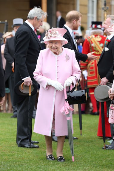 Britain's Queen Elizabeth II and Britain's Prince Harry, Duke of Sussex greet guests at the Queen's ...