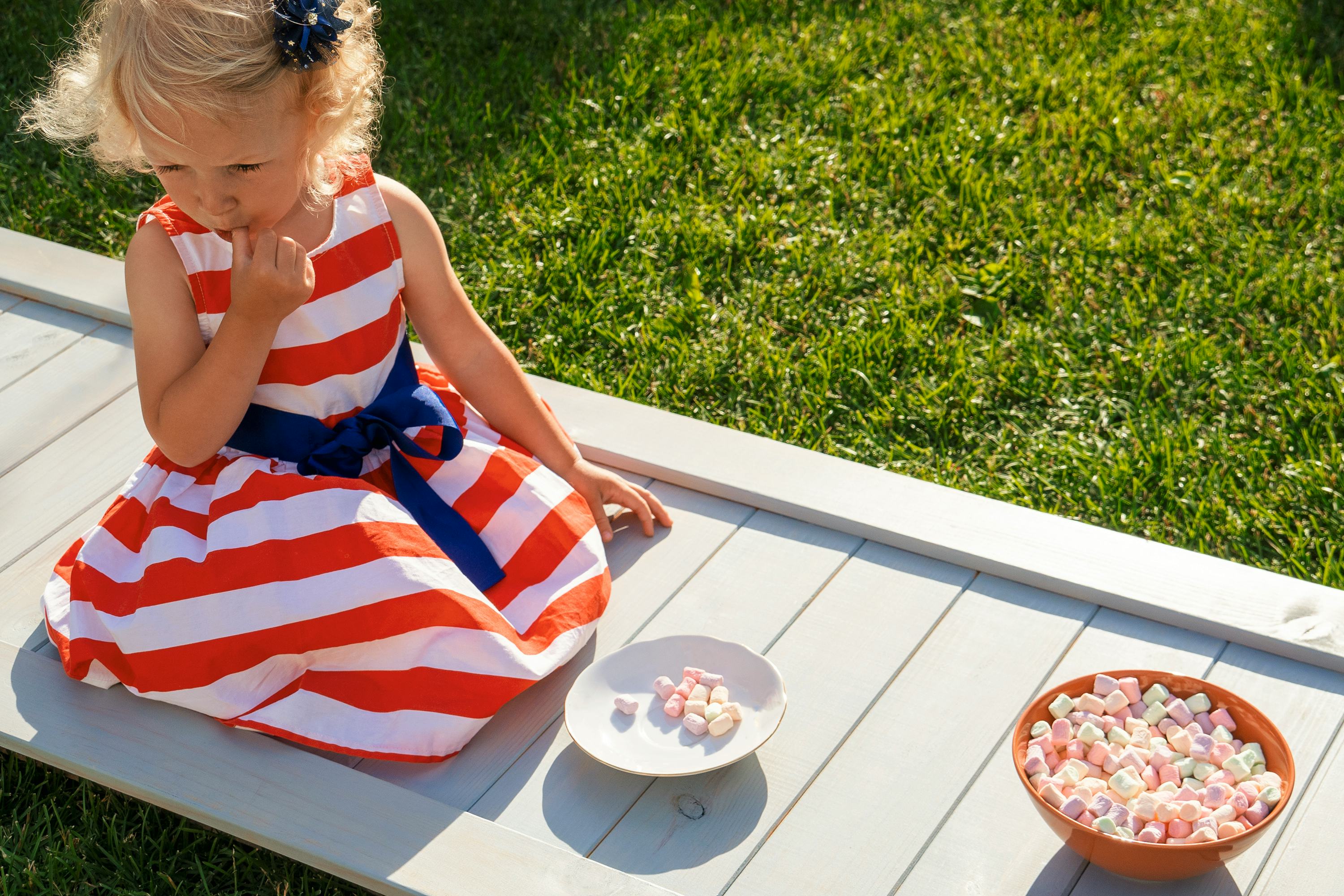 A child eats marshmallows from a bowl.