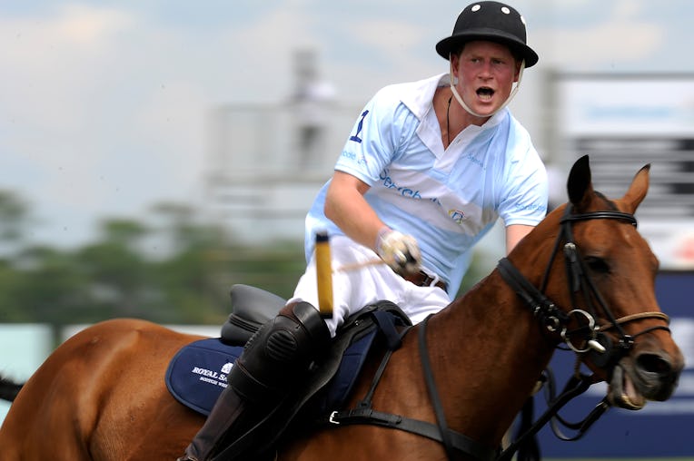Britain's Prince Harry (R) plays for the Sentebale polo team against the St. Regis team during the S...