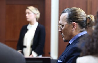 US actress Amber Heard (L) testifies as US actor Johnny Depp looks on during a defamation trial at t...