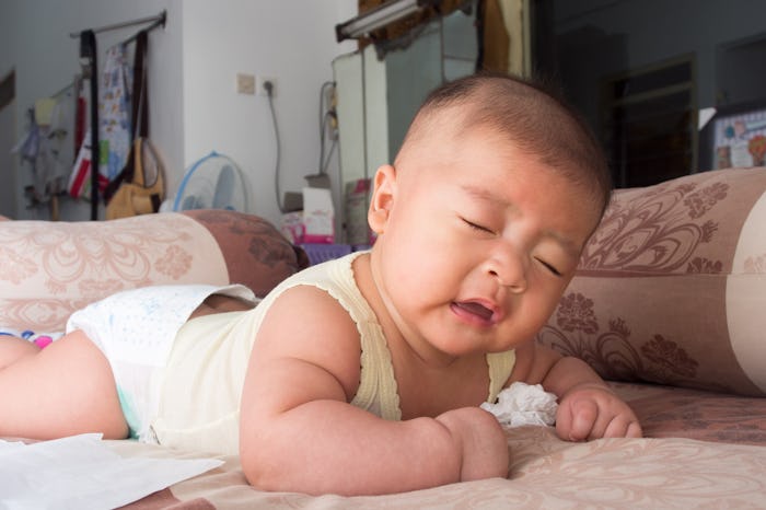 Everything you need to know about your sneezing baby, like this Asian infant who is mid-sneeze.