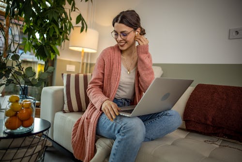 A woman works on a laptop. Your may 9 zodiac sign daily horoscope for 2022.
