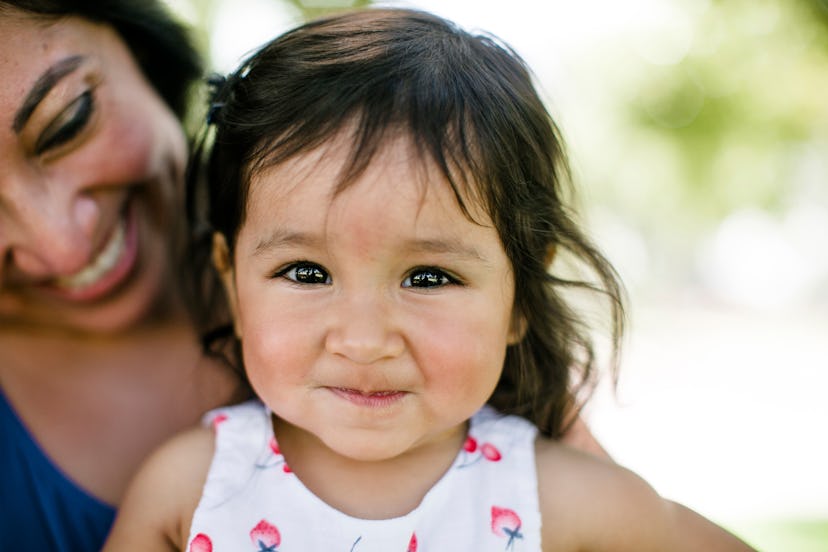 Closeup of mother and cute dark-haired baby at the park, short middle names for girls