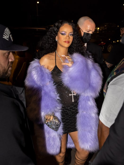 rihanna wearing a black gucci dress with a purple fur coat 