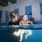 A baby takes a swim lesson.