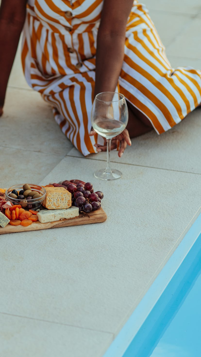 Close up of woman eating food at gathering with her friends near pool