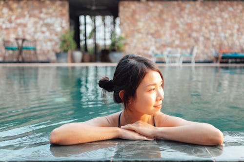 Beautiful young woman relaxing in the pool in resort. Your june 2 zodiac sign daily horoscope