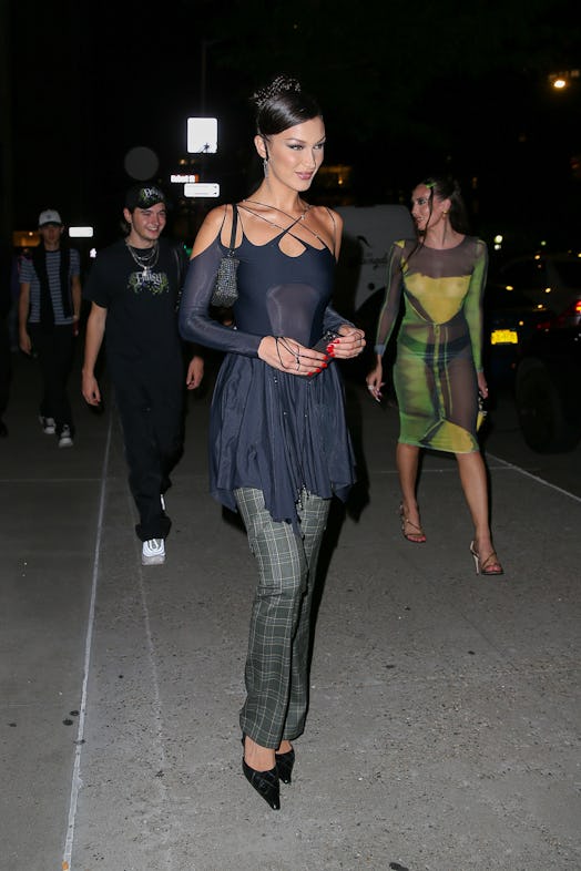 bella hadid wearing a black dress over plaid pants