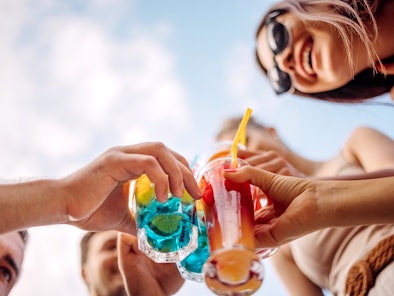 Friends at a pool party enjoy 2022 Summer cocktails.