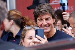 CANNES, FRANCE - MAY 18: Tom Cruise poses with a fan for a selfie after leaving the photocall of "To...
