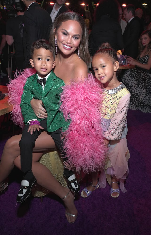 Chrissy Teigen with her two children. Her daughter Luna just lost a baby tooth play-fighting with he...