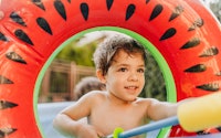 Photo of a little boy with a squirt gun during a water fight in his yard, best backyard toys under $...