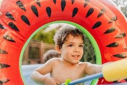 Photo of a little boy with a squirt gun during a water fight in his yard, best backyard toys under $...