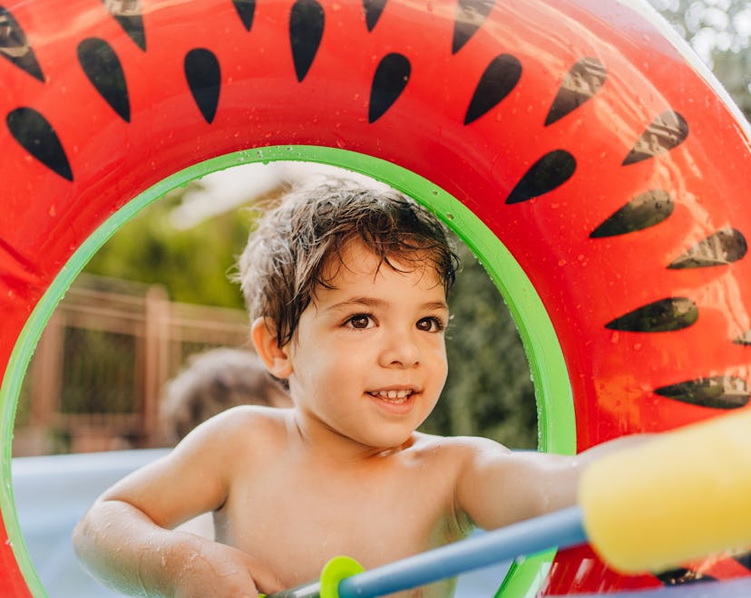 Photo of a little boy with a squirt gun during a water fight in his yard, best backyard toys under $...