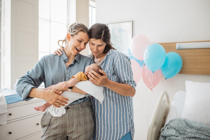 Two mothers at hospital ward holding their new born baby boy.