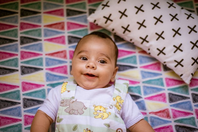 Smiling baby lying down with Roman boy name