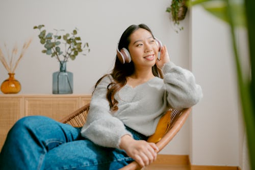 Woman listens to music on a chair. Here's your June 15 zodiac sign daily horoscope.