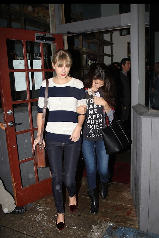 taylor swift wearing a striped sweater with dark jeans and flats