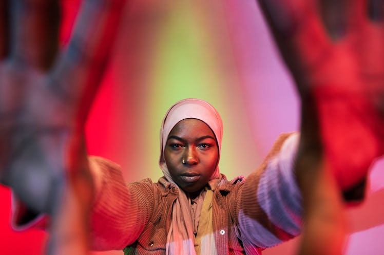 Young woman reaches her hands out to grab the camera as she thinks about her June 27, 2022 weekly ho...