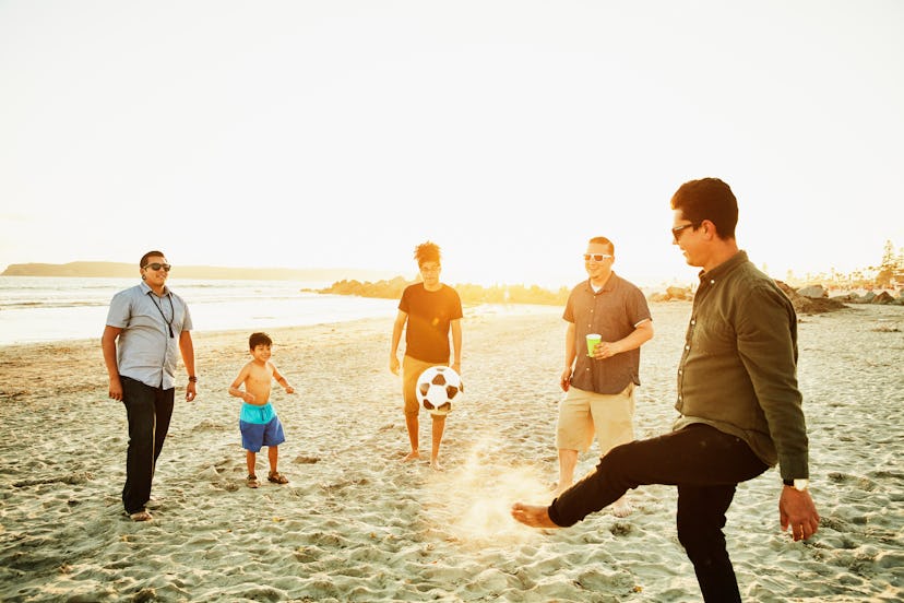 boy playing soccer with uncles on beach, instagram captions for your uncle on father's day