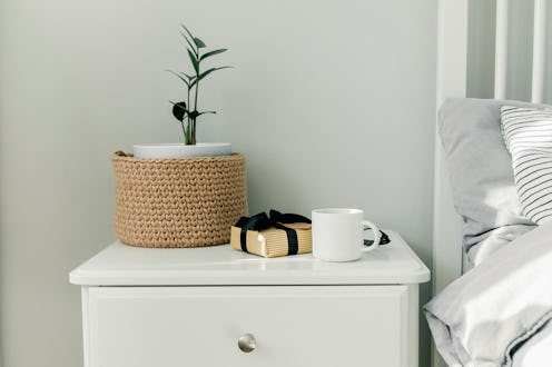 Morning cup of coffee, gift present, black wooden calendar on bedside table on Happy Fathers Day. Ho...