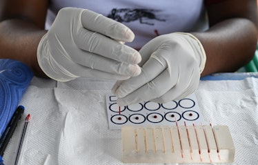 Technicians analyze blood drawn from people as they take part in an Human African Trypanosomiasis, a...
