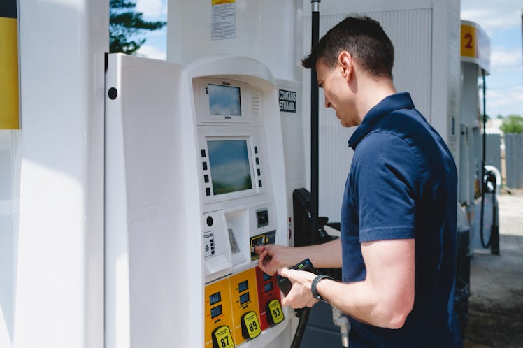 Close-up of mid adult white man purchasing gas at pump