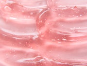 Texture of gel cream. Liquid hyaluronic acid gel on pink background.
