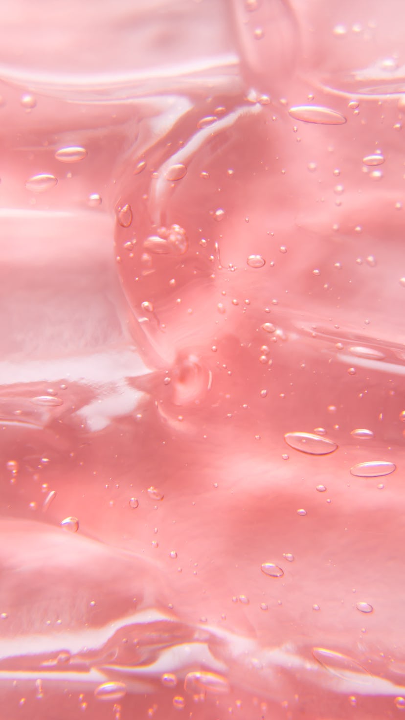 Texture of gel cream. Liquid hyaluronic acid gel on pink background.