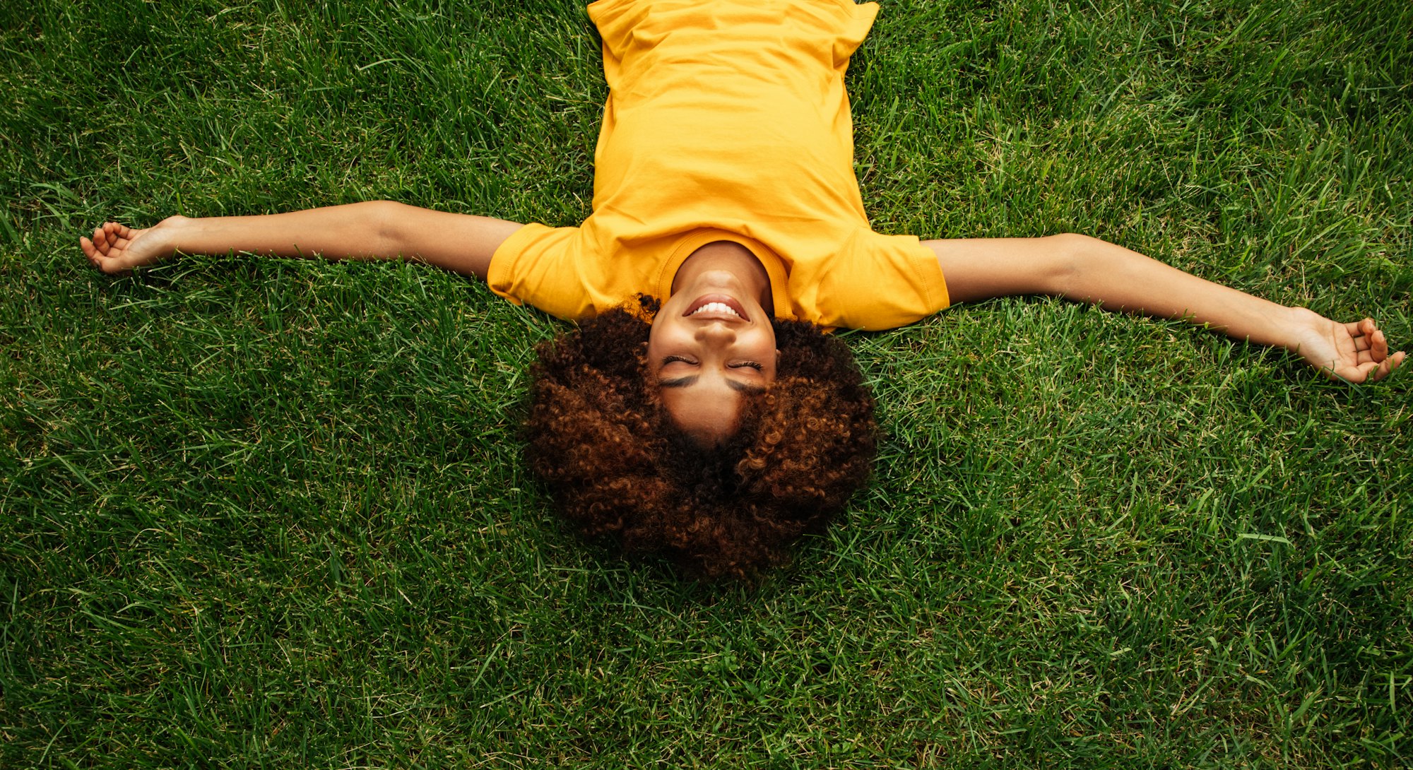 A woman lies in the grass. cancer season 2022 do's and don'ts.