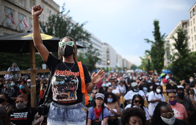 WASHINGTON, DC - JUNE 19: People listen as Lift Every Voice and Sing is performed at the intersectio...