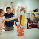 A group of kids play at a pre-school at a table