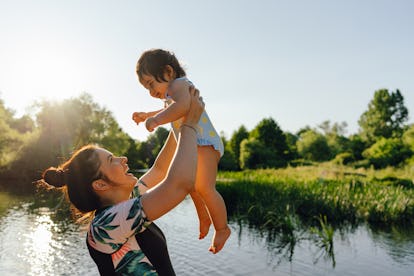 Photo of mother and her baby girl spending summer days by the river, why does my baby call everyone ...