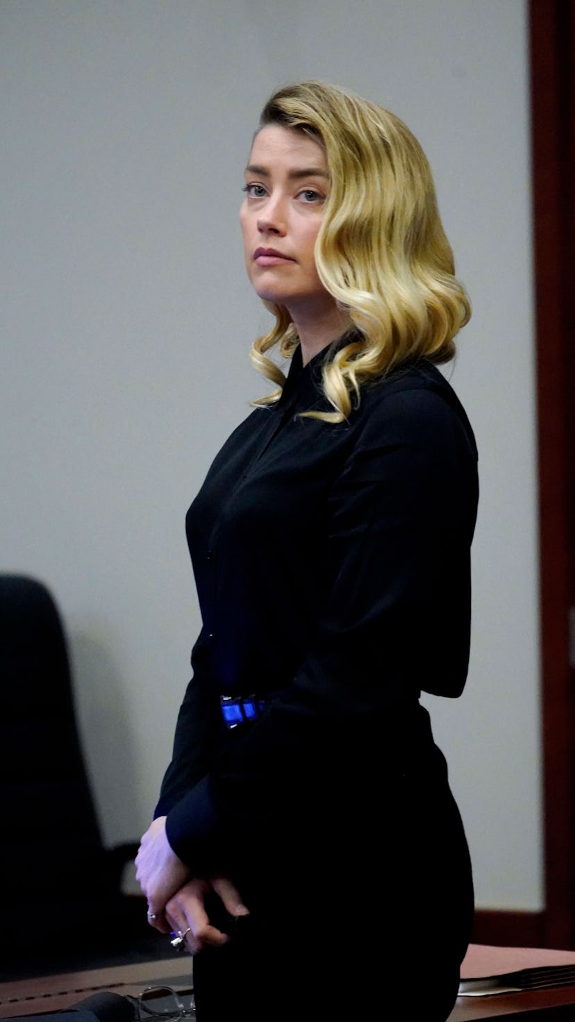 US actress Amber Heard stands and watches the jury leave as a lunch break starts at the Fairfax Coun...