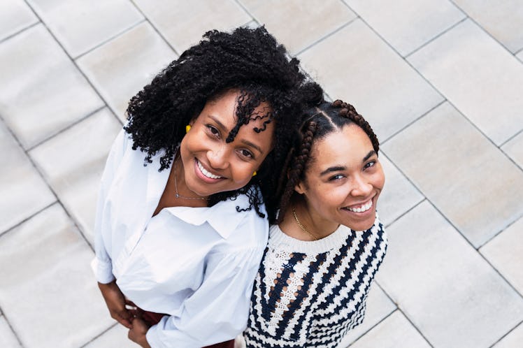 two women looking up and smiling at camera as they think about cancer compatibility