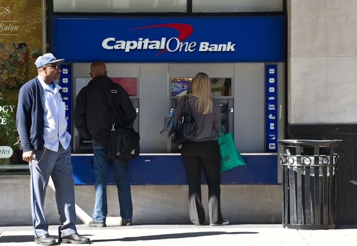 People use an ATM at a Capital One Bank branch in Washington on April 13, 2012.   AFP PHOTO/Nicholas...