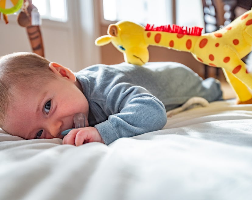 baby in crib playing with toy, best toys for 3 month olds