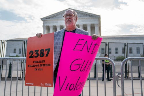 WASHINGTON, DC - JUNE 08: A protester holds signs calling for an end to gun violence in front of the...