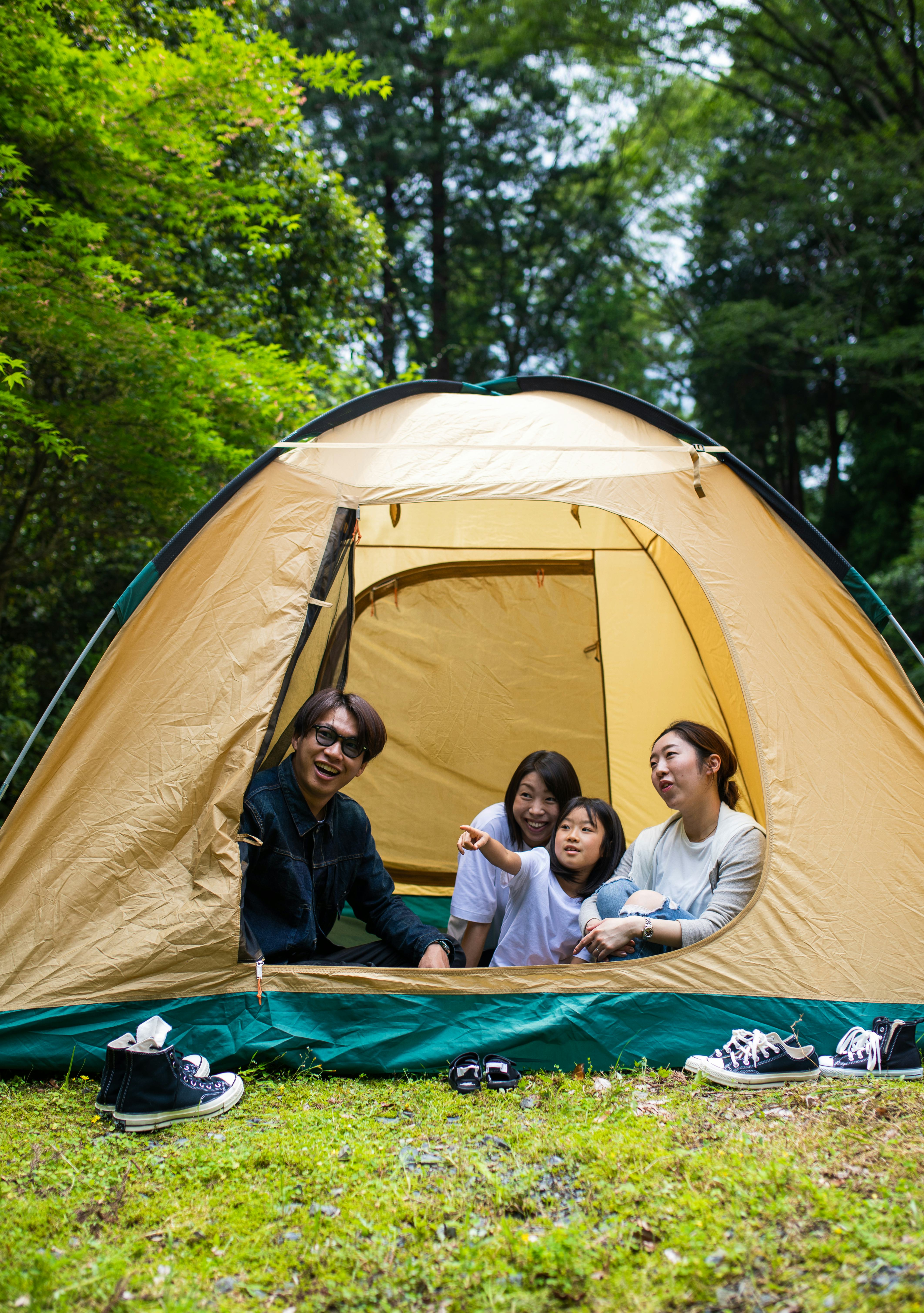 A family camping with kids together in a tent in the forest.
