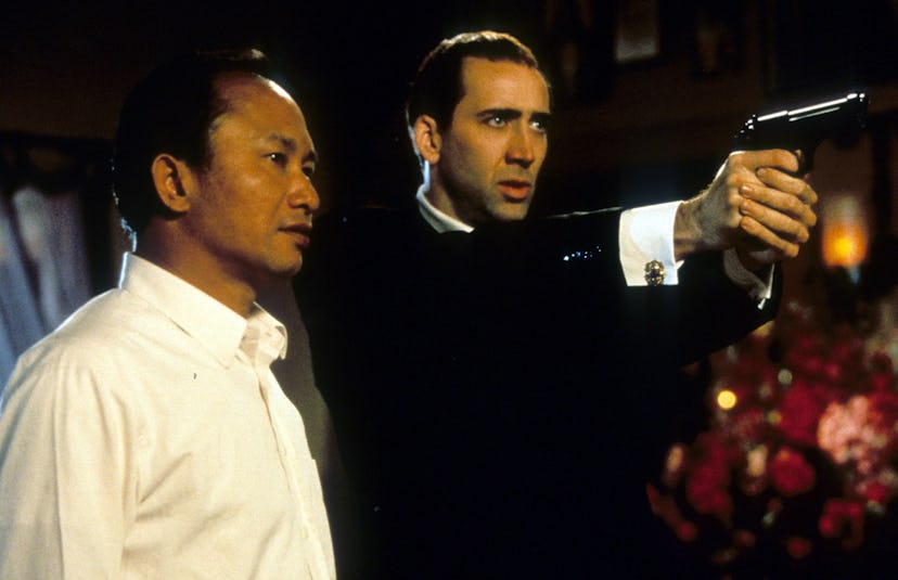 Director John Woo watches as Nicolas Cage aims pistol in between scenes from the film 'Face/Off', 19...