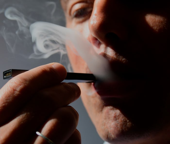 An illustration shows a man exhaling smoke from an electronic cigarette in Washington, DC on October...