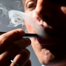 An illustration shows a man exhaling smoke from an electronic cigarette in Washington, DC on October...