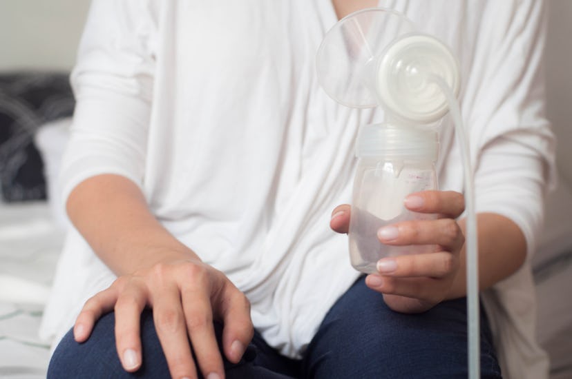 Midsection of a young Southeast Asian mother holding a breast pump