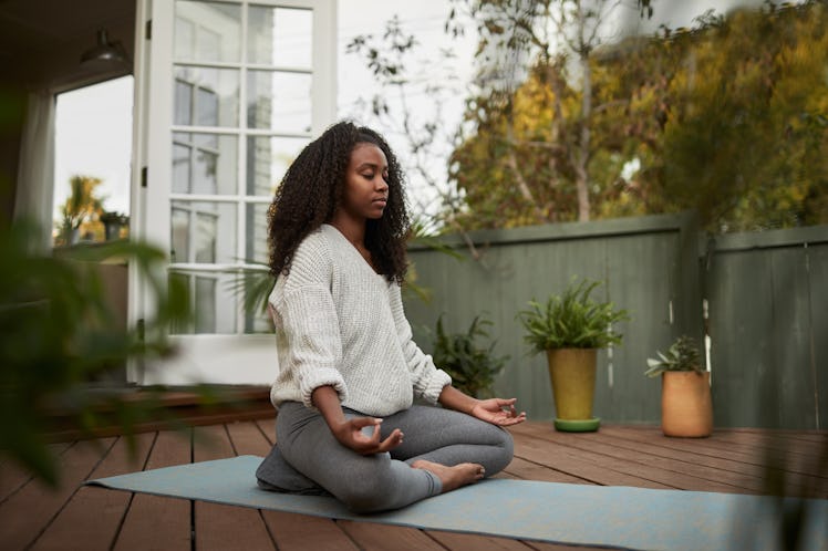 A woman mediating in lotus pose during a summer solstice yoga sequence.