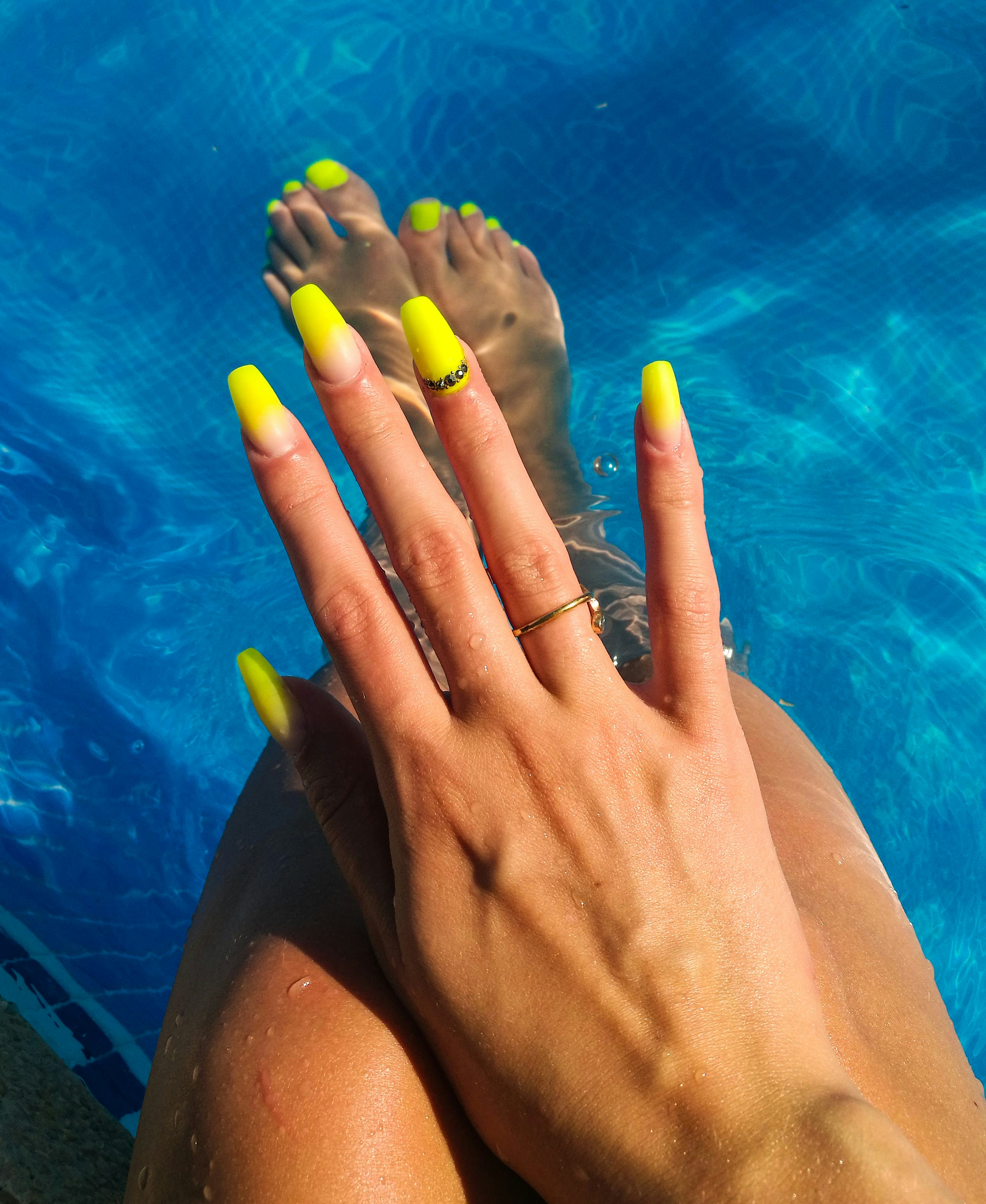A woman shows off neon coffin nails with 3d nail art, two of summer 2022's nail trends 