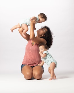 a mom of twins playing with her kids in an article about everything to know about breastfeeding twin...